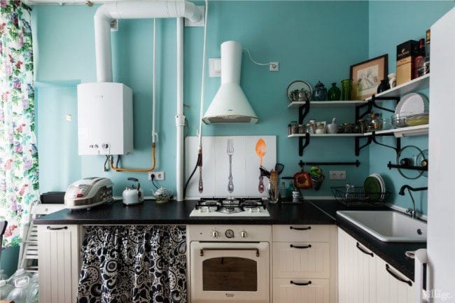 Witte boiler en witte afzuigkap in het interieur van een blauwe keuken in een retro-stijl