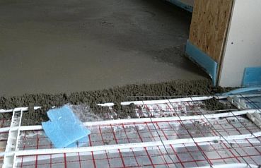 Fotografie - Nalévání betonového potěru na potrubí podlahového vytápění